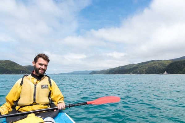Homem em caiaque no mar da costa de Abel Tasman
