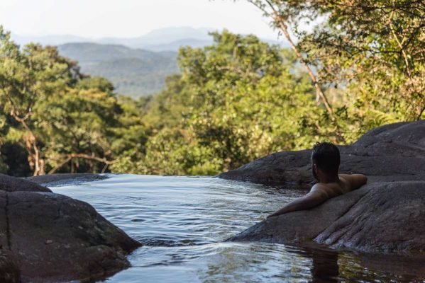 Homem em piscina natural com vista para as montanhas no Salto Bom Jardim, cachoeira perto de Curitiba