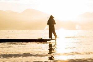 Pescador em lago no Mianmar durante a hora dourada