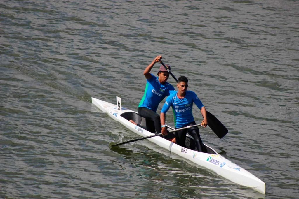 Atletas remando em canoa para duas pessoas